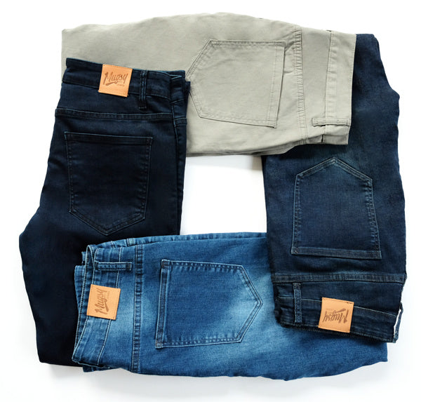 Four pairs of jeans in different colors arranged in a circle.