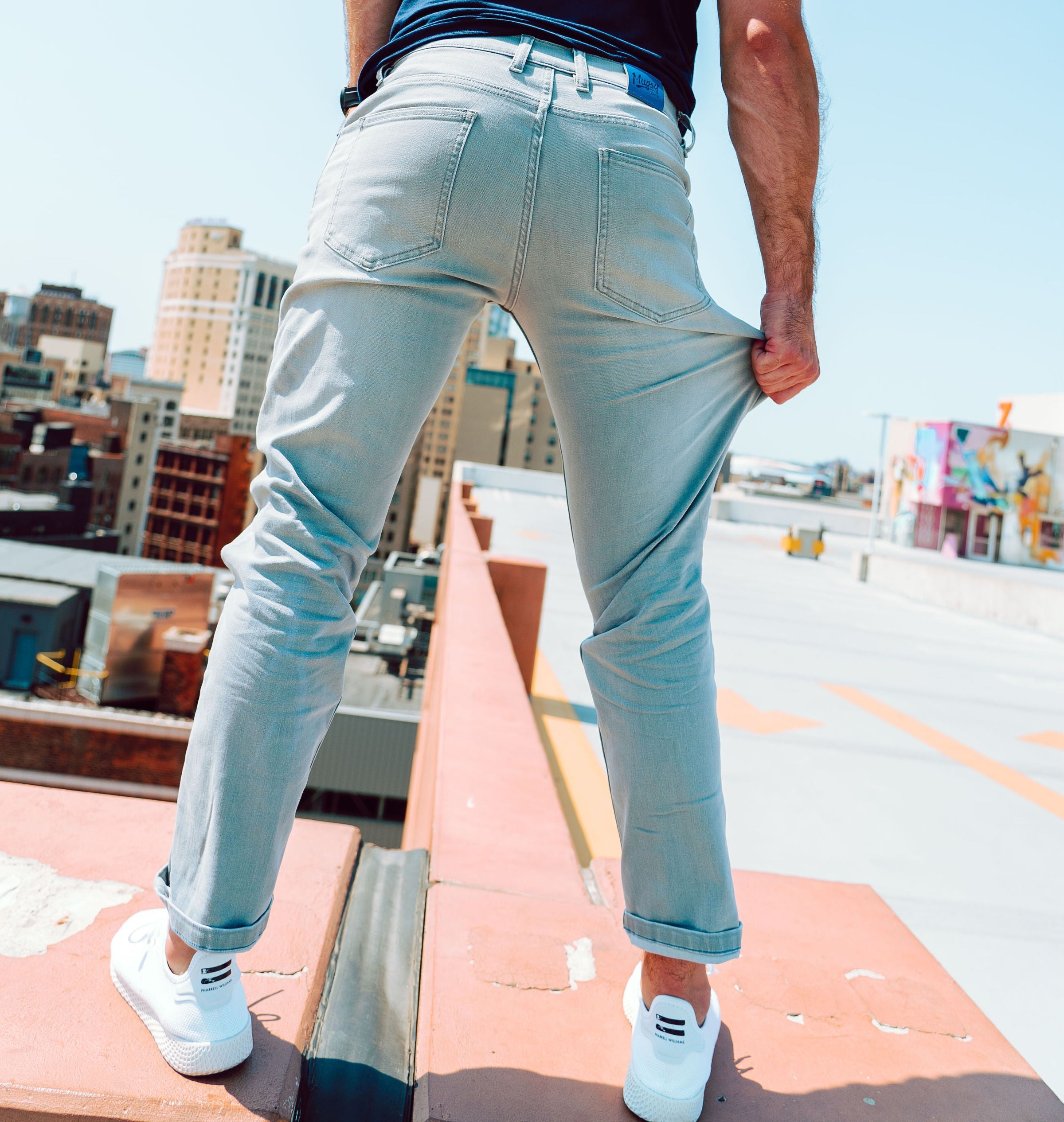 Person wearing Mugsy stretch jeans, standing on a rooftop