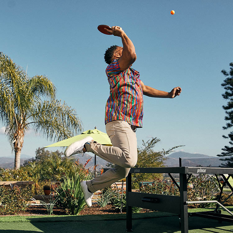 A person jumping to catch a frisbee in a colorful outdoor setting.
