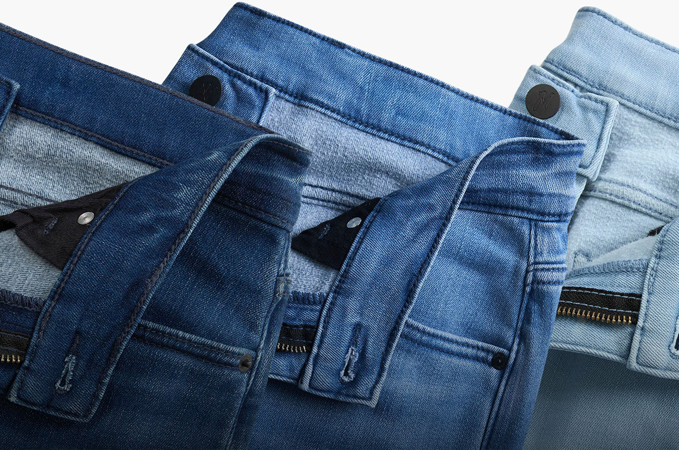 Three pairs of jeans in varying shades of blue, showcasing different styles.