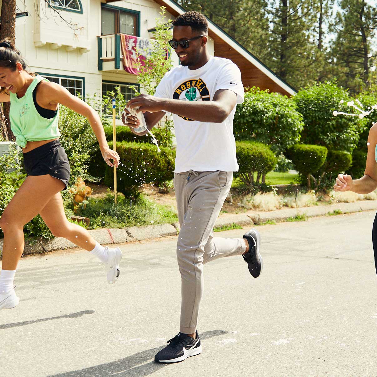 Three people running outdoors in casual athletic wear.
