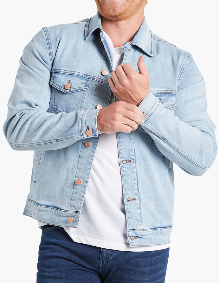 Model wearing a light blue stretch denim jacket, adjusting the cuff.