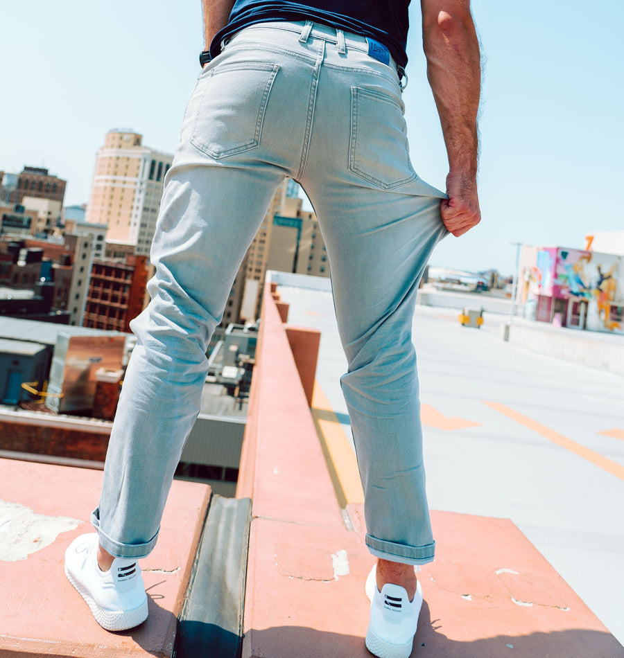Person wearing Mugsy stretch jeans, standing on a rooftop