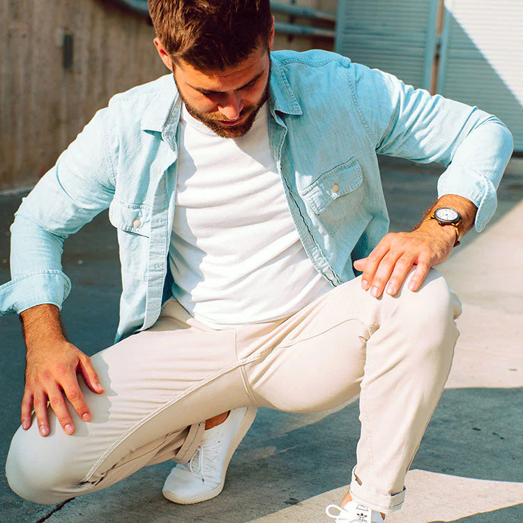 Man wearing beige stretch chinos, squatting outdoors