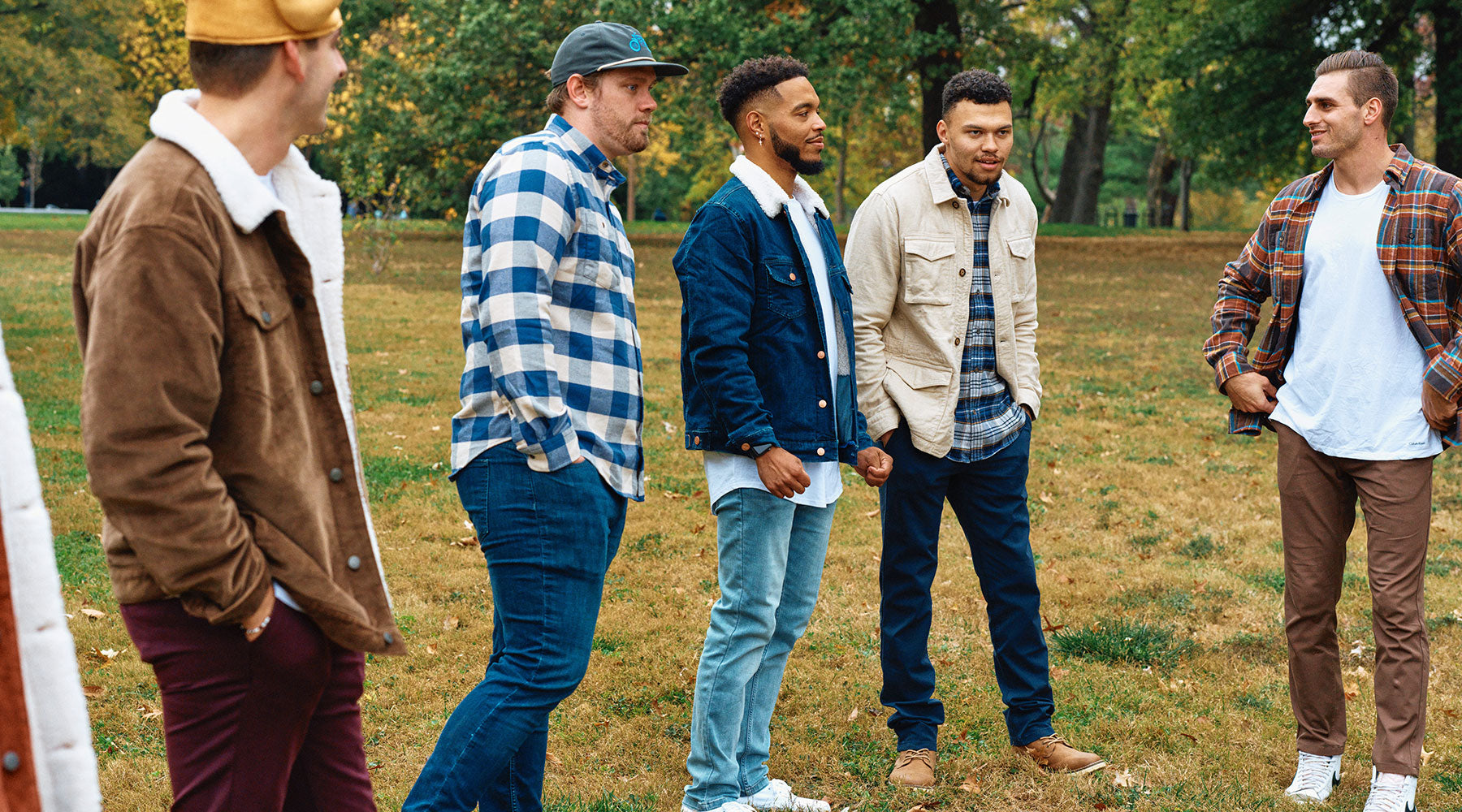Five men standing outdoors in fall fashion including sherpa-lined jackets, plaid shirts, denim, and casual pants, showcasing men's fall style in 2024.