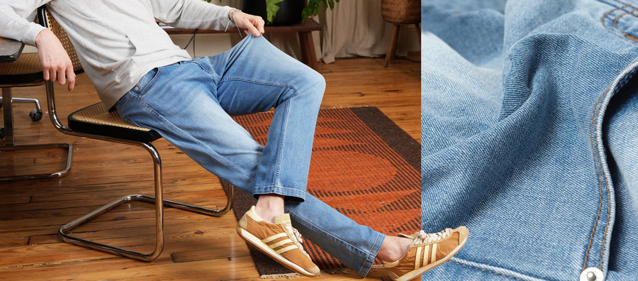 Seated side view of light-wash men’s jeans showing relaxed straight fit and soft stretch denim on a hardwood floor