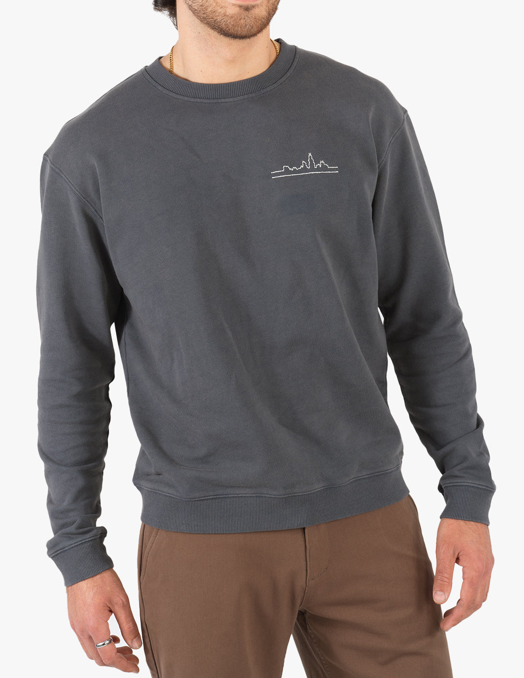 Model wearing a dark gray sweatshirt with a Chicago skyline design on the chest.