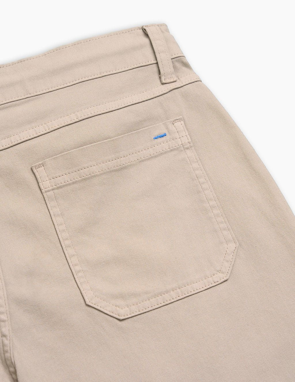 Beige pants back pocket and belt loop, close-up showing stitching detail and small blue bartack.