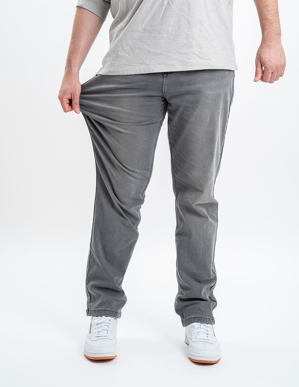 A person wearing gray Beans Casual jeans, pulling the fabric to show flexibility.