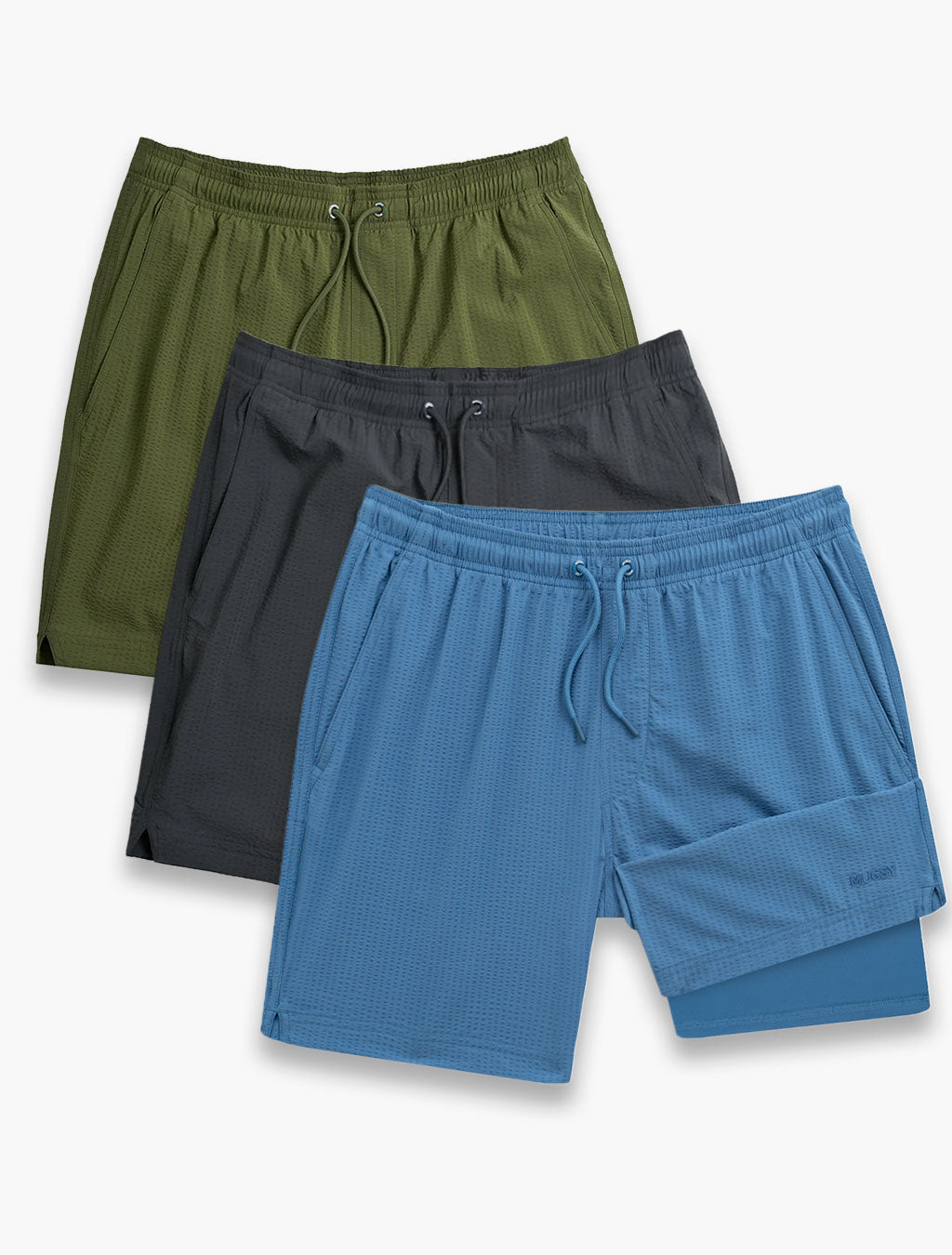Flat lay of three swim shorts (blue, charcoal, olive) showing elastic waistband, drawstring, textured quick-dry fabric on white background