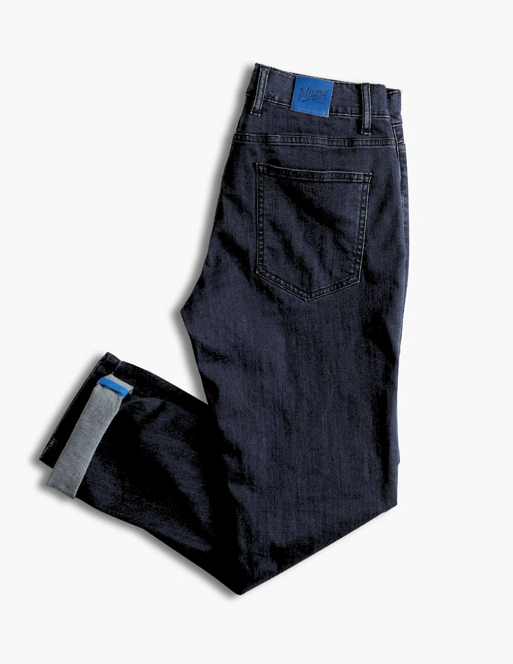 Dark indigo jeans folded to show back pocket and cuffed hem