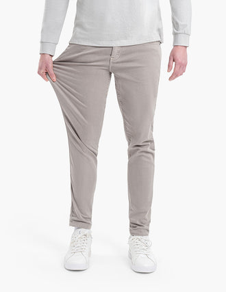 A person demonstrating the fit of Bucks Tapered jeans in light tan color.