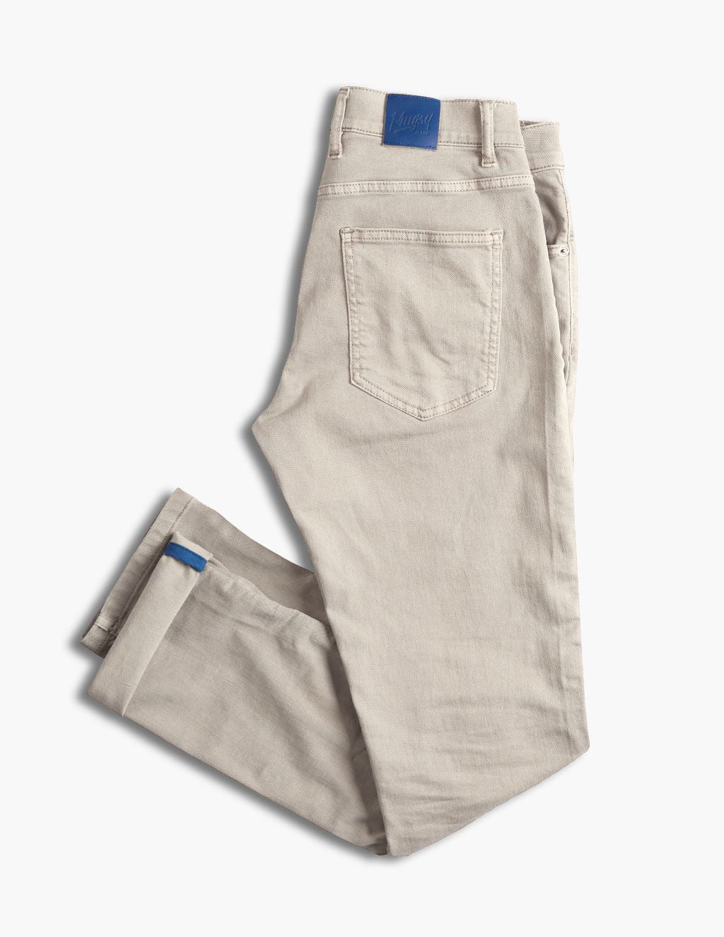 Beige folded jeans with back pocket, blue brand patch at waist and blue cuff tab