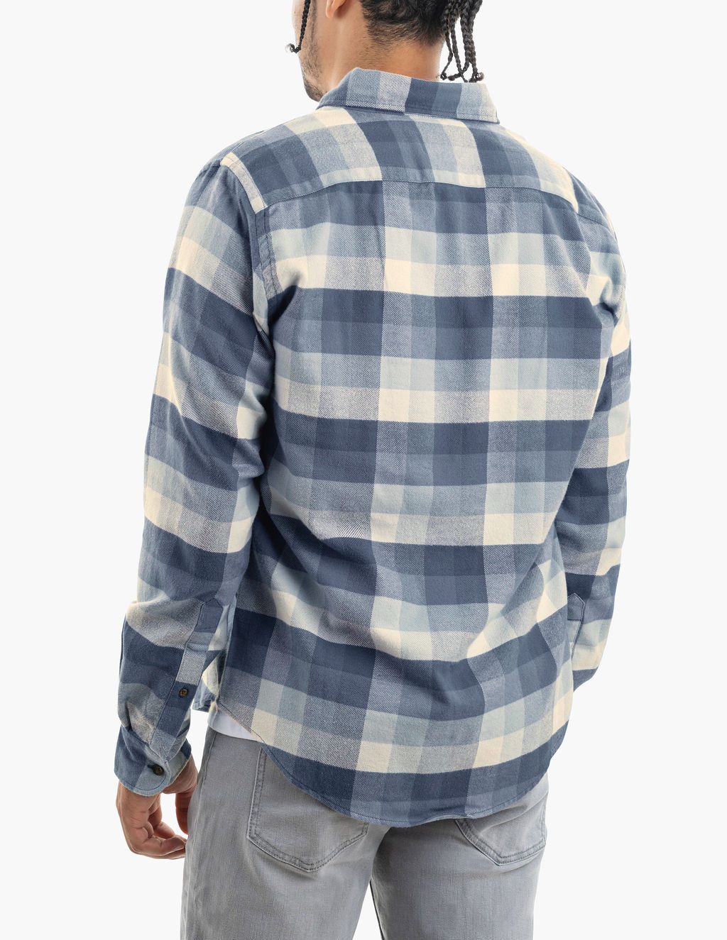 Rear view of person wearing blue-and-white large-check flannel shirt and light gray jeans, braided hair at nape