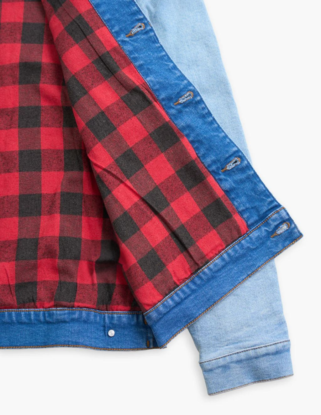 Light-wash denim jacket opened to reveal black and red plaid flannel lining.