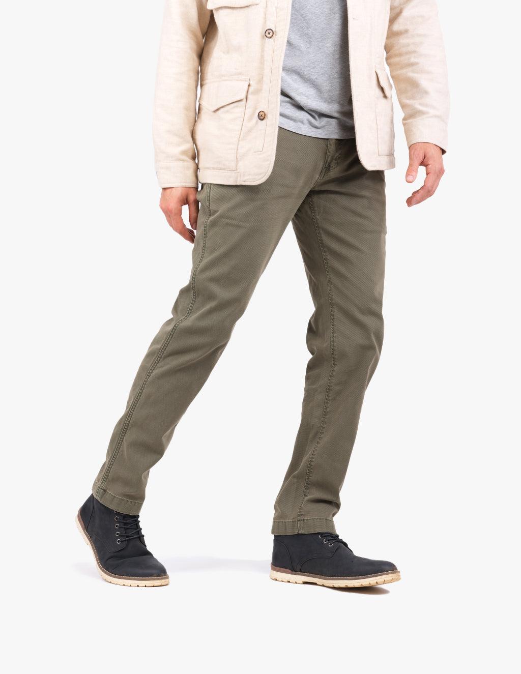 Cropped view of a man wearing olive-green casual trousers and black lace-up chukka boots, showing fit and hem.