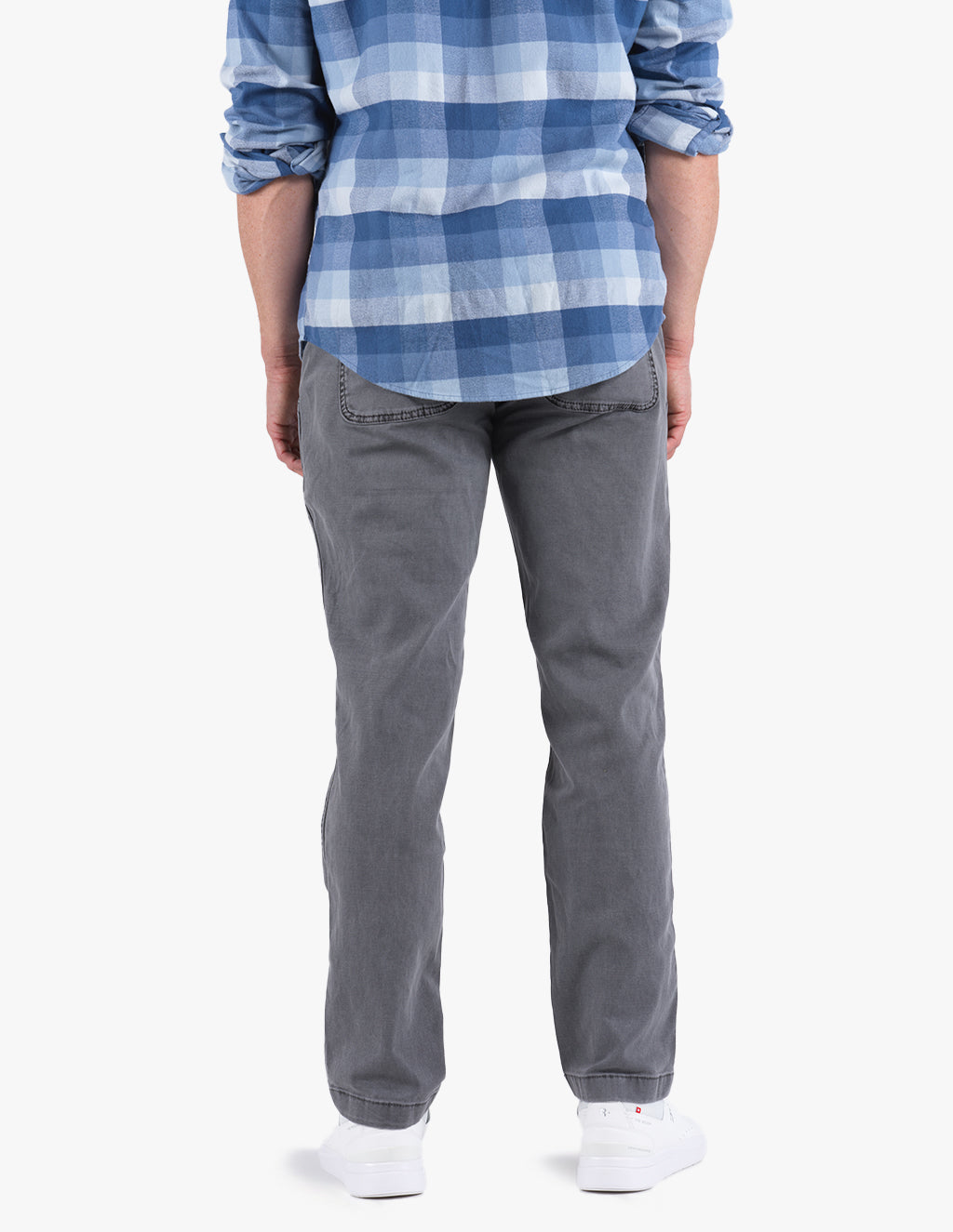 Rear view of person in blue plaid shirt, gray pants and white sneakers