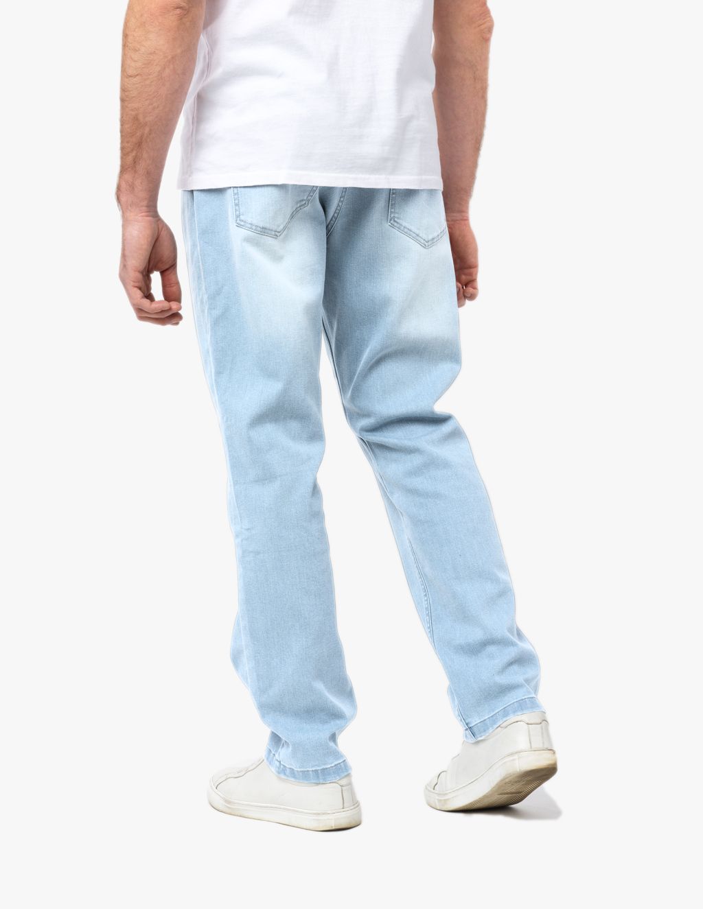 Man wearing light blue casual jeans and white sneakers, viewed from the back.