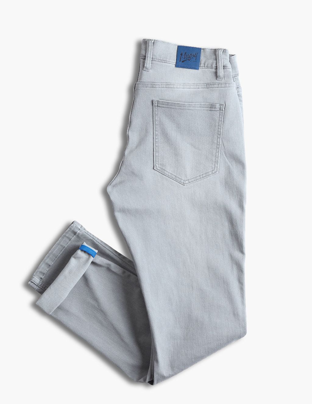 Light-gray folded jeans with back pocket and blue 'Mugsy' label on waistband