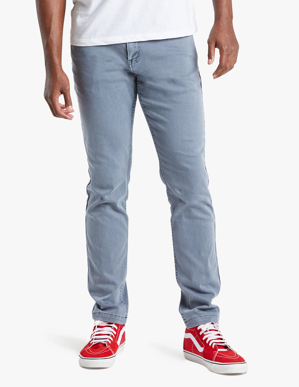 Model wearing blue-gray Logans jeans with red sneakers