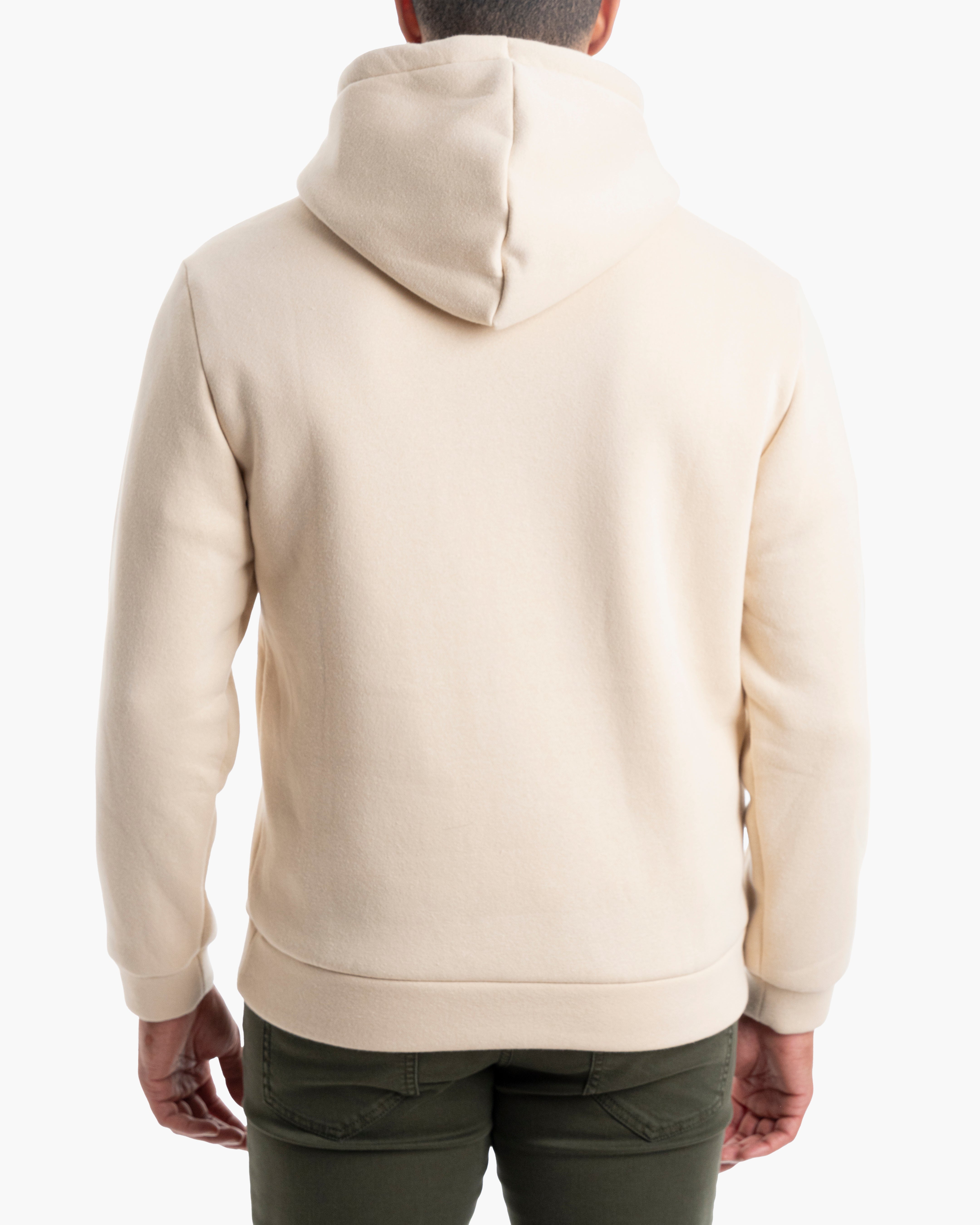 Back view of a person wearing a cream hoodie and olive-green pants, hands at sides