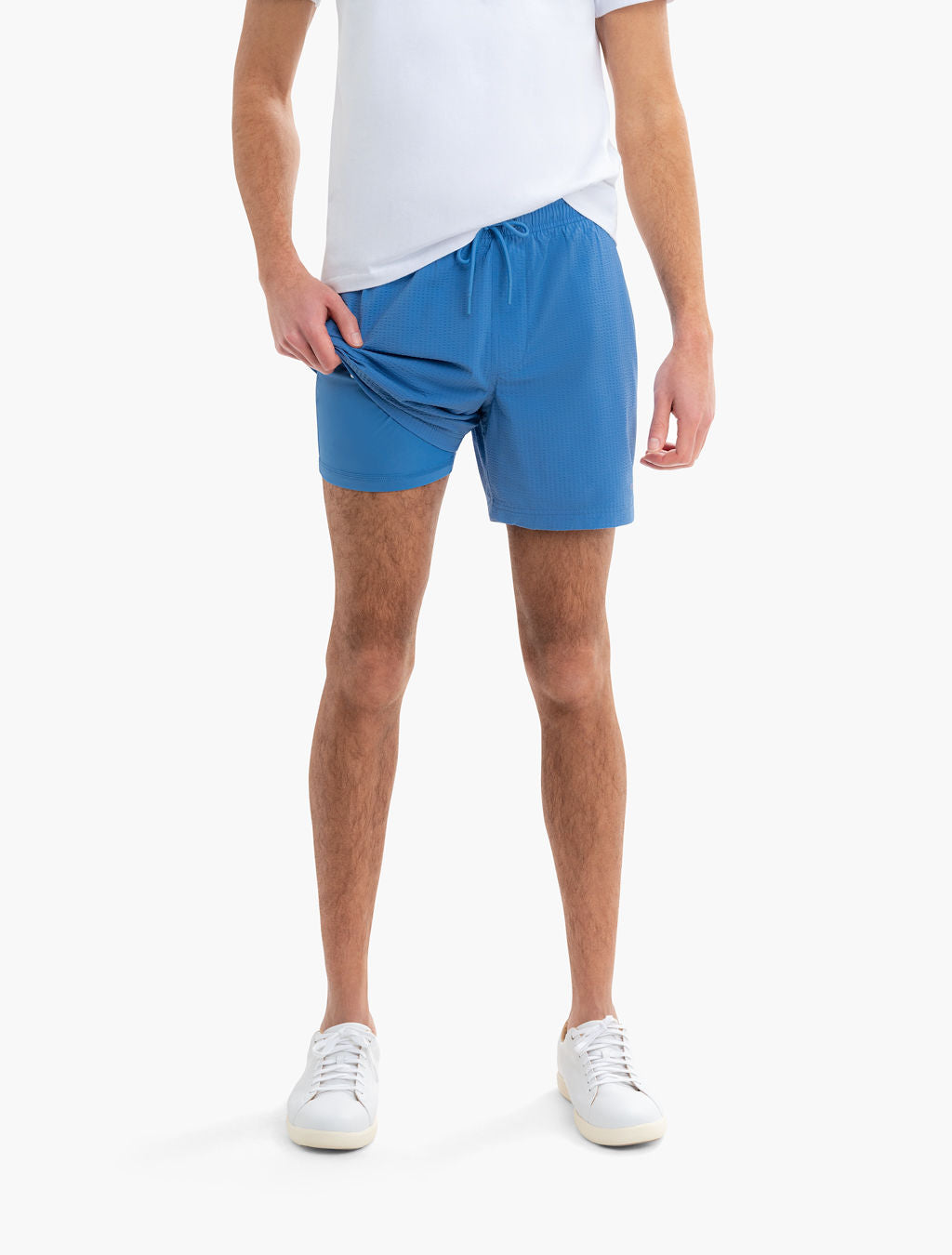 Front view of Pacifics blue swim shorts on a model showing built-in liner and 6 in inseam on white background
