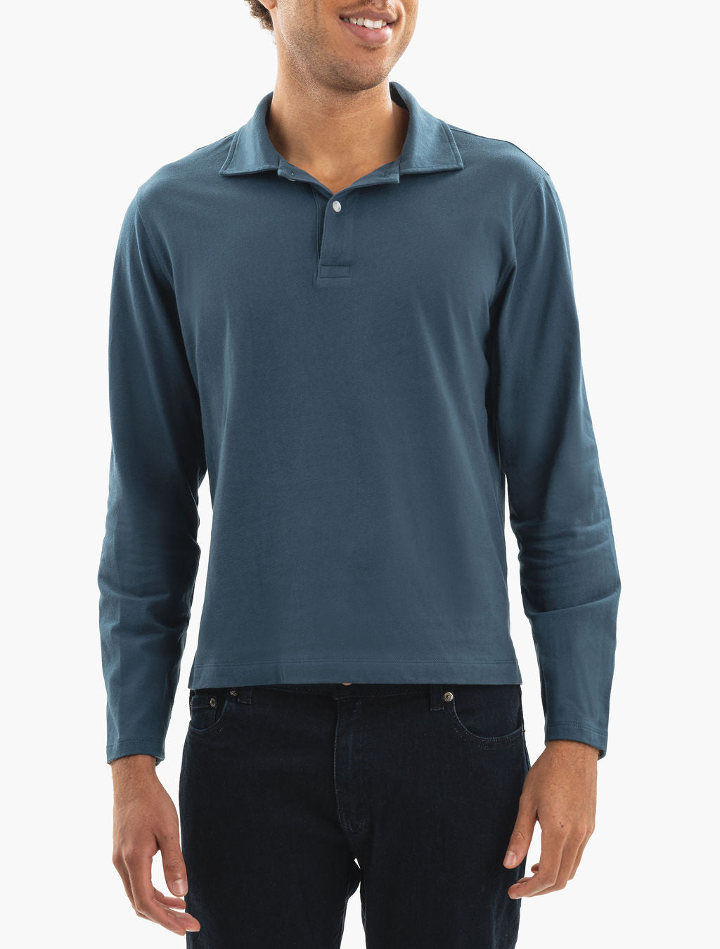 Model wearing teal long-sleeve polo shirt and dark jeans, front view cropped at chin and hips.