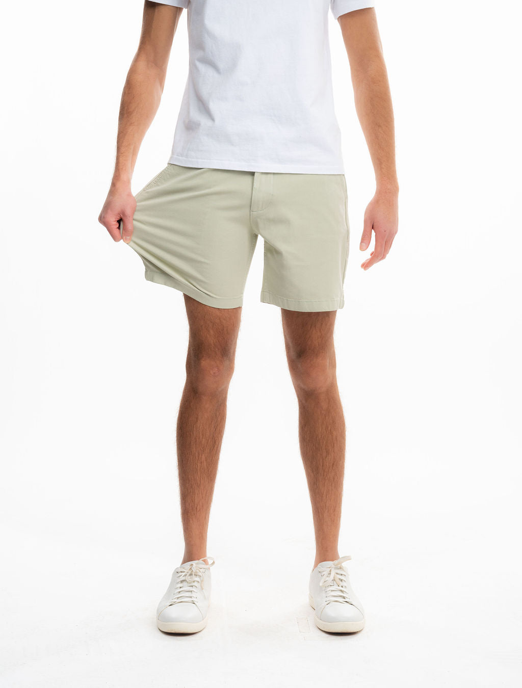 Front view of Willows chino shorts in light sage on model showing stretch fabric and mid-thigh length on white background
