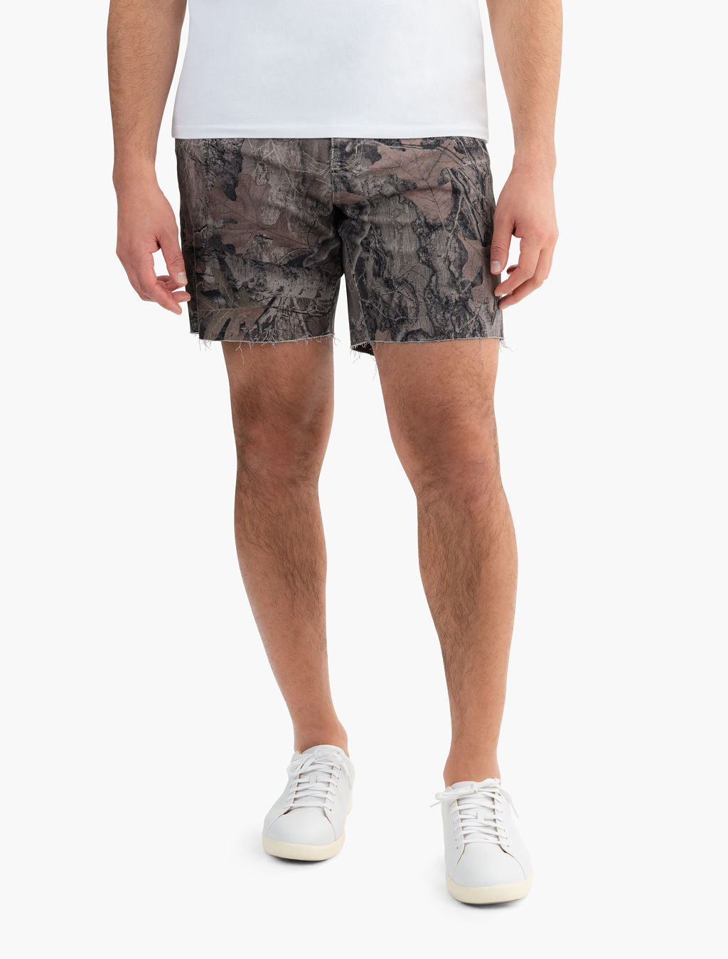 Front view of Realtree Edge camo cut-off shorts on model showing frayed hem and mid-thigh length on white background