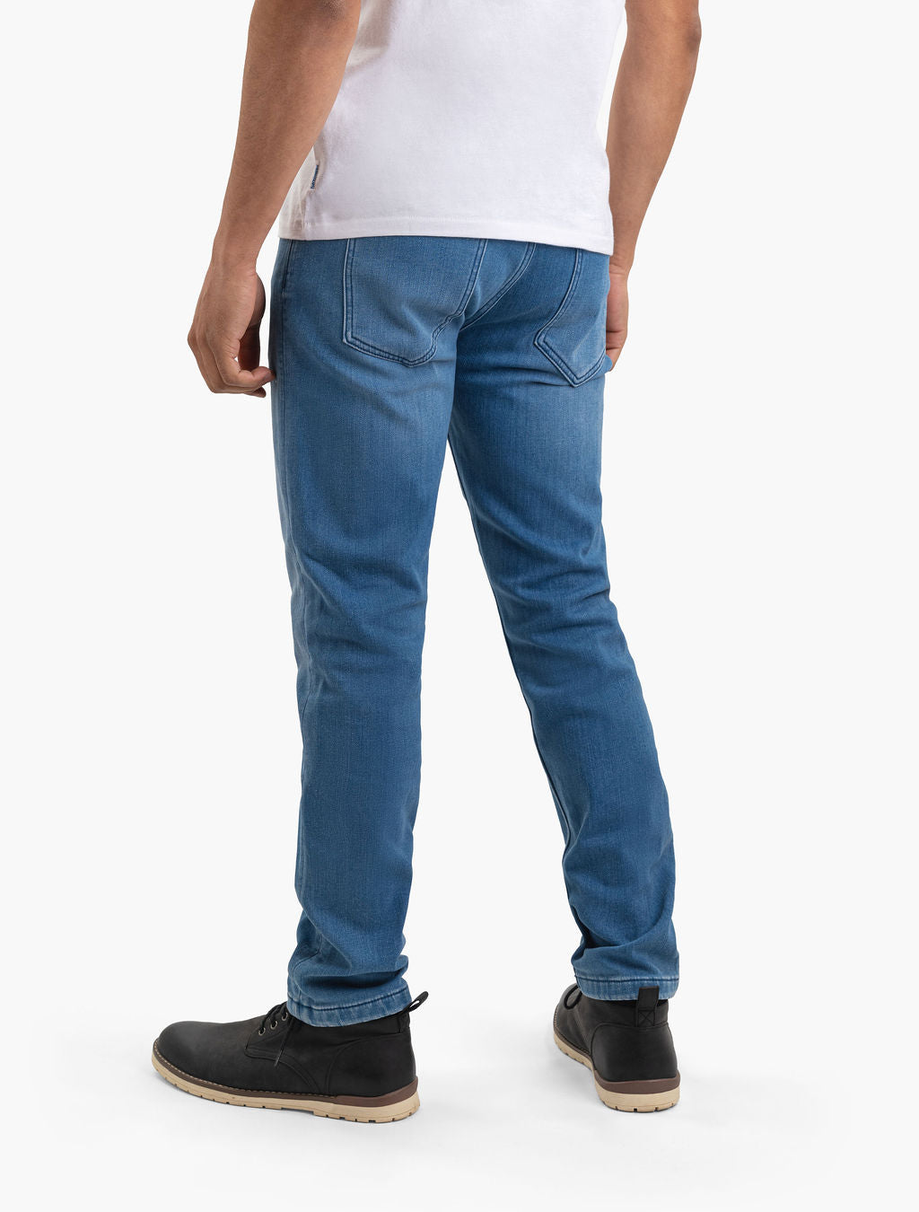 Rear view of person wearing light-blue slim-fit jeans, white T-shirt, and black lace-up boots.