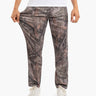 Men's brown Realtree camouflage lounge pants, full-length, model wearing white sneakers, holding fabric to show relaxed fit.