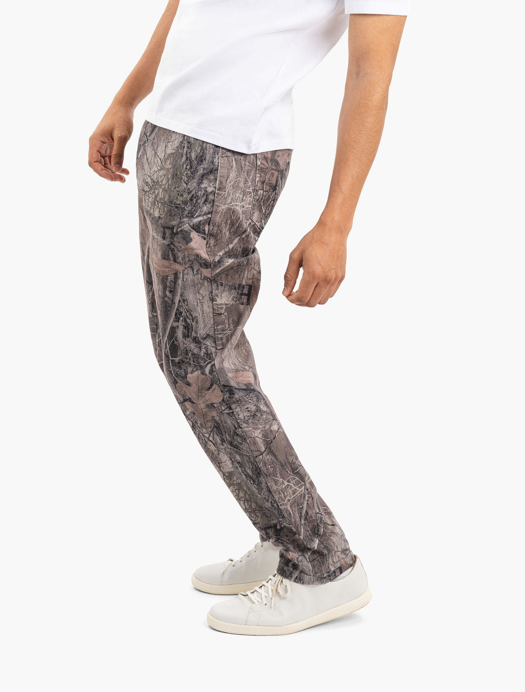 Men's Realtree camo casual pants on model with tapered leg and white sneakers