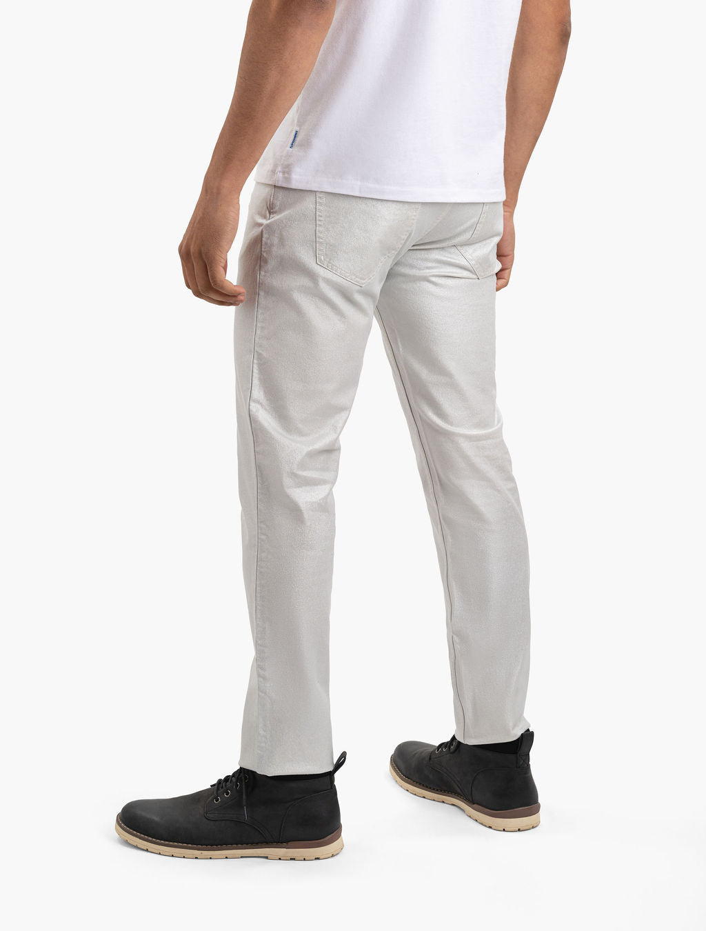 Rear view of a person wearing champagne-colored slim pants and black lace-up ankle boots.