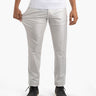 Men’s silver metallic stretch pants, front view; model pulls thigh fabric to show stretch, worn with white tee and black boots