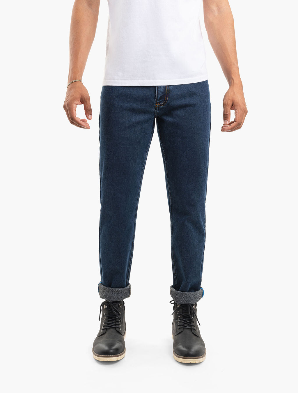 Men's dark-blue cuffed straight-leg jeans worn with black lace-up boots and a white T-shirt, front view, waist-cropped