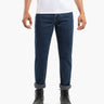 Men's dark-blue cuffed straight-leg jeans worn with black lace-up boots and a white T-shirt, front view, waist-cropped