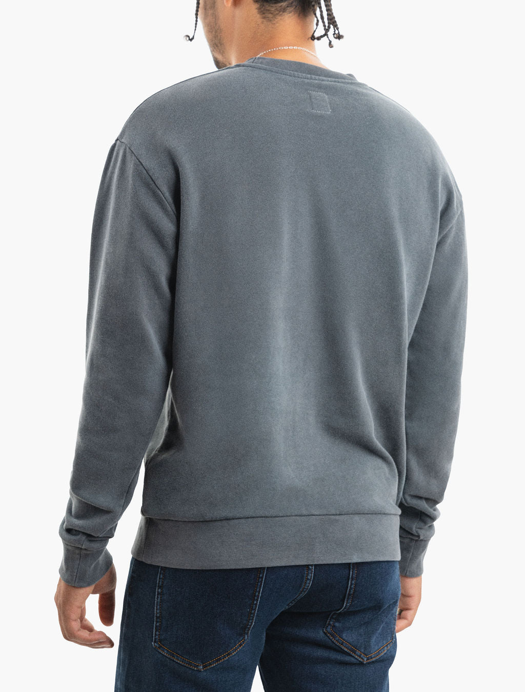 Rear view of a person wearing a faded slate-gray crewneck sweatshirt and dark blue jeans