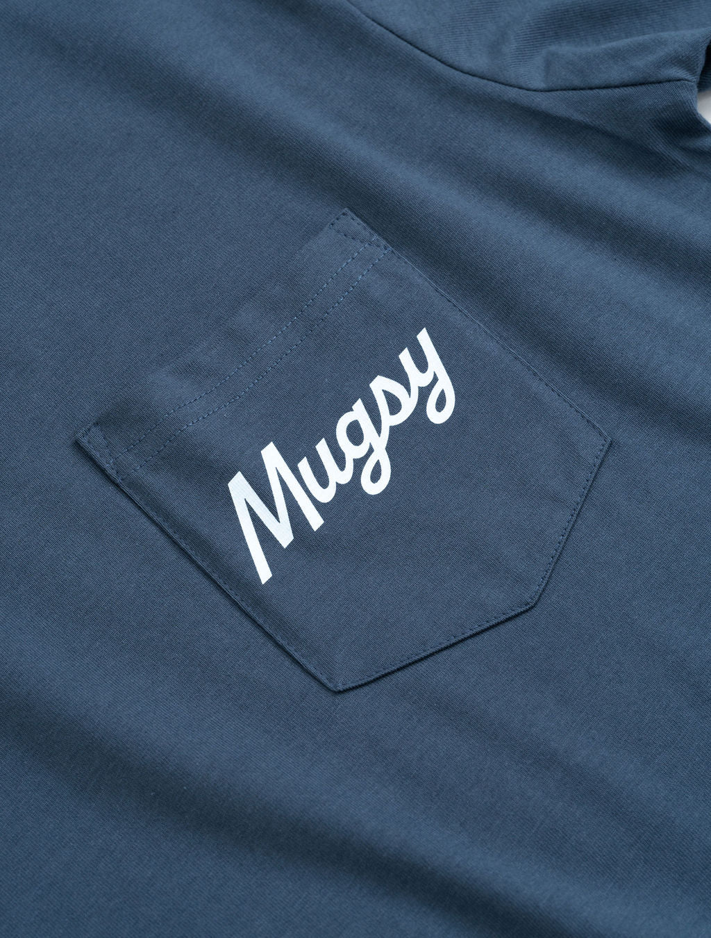 Navy T-shirt chest pocket with white 'Mugsy' script printed on pocket