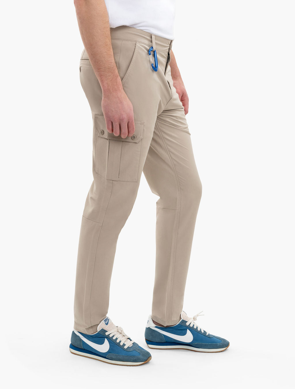Lower body wearing beige slim cargo pants with side flap pocket and a blue carabiner on belt loop, blue-and-white sneakers.