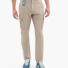 Men's beige cargo pants with flap pockets and blue carabiner on belt loop; model wearing blue NIKE sneakers.