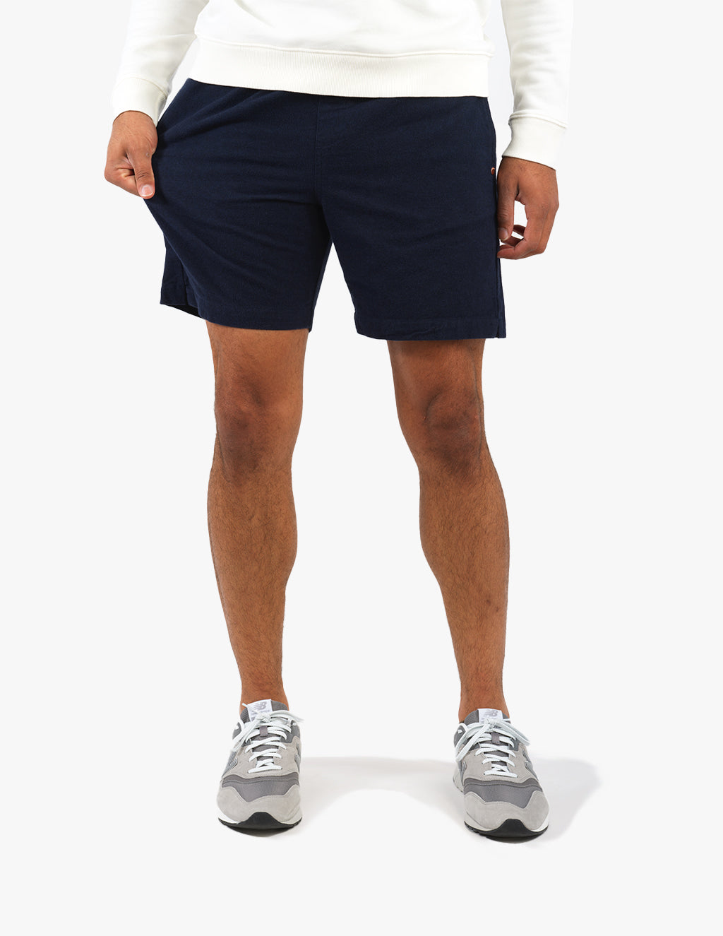Model wearing navy Navals shorts with a white top and sneakers.