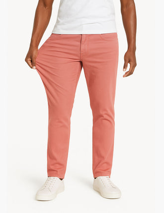 Coral straight-leg stretch pants on model, fabric pulled to show stretch