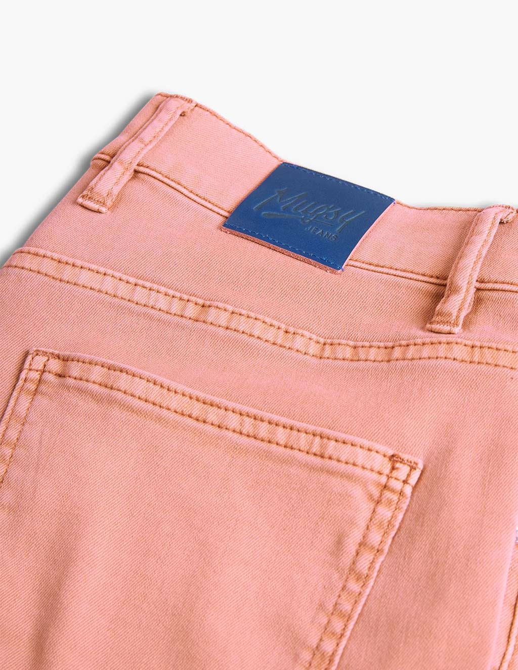 Pink jeans back pocket with blue label reading 'Mugsy JEANS'