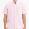Front view of pink seersucker short-sleeve shirt on model showing vertical stripes and chest pocket on white background
