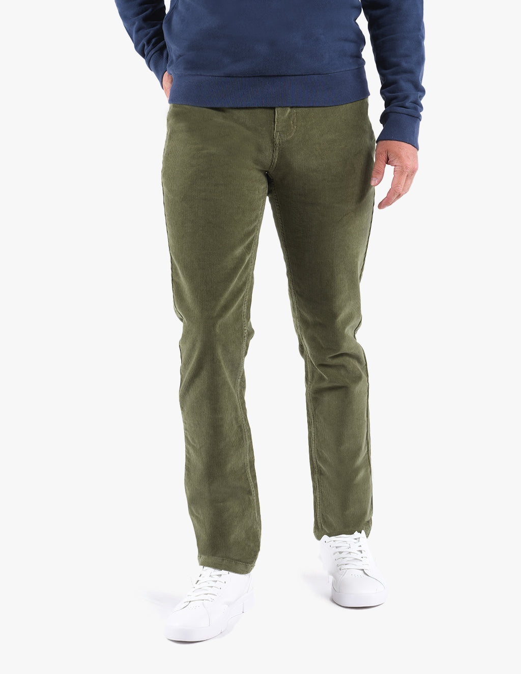 Model wearing olive green pants with white sneakers and a navy blue shirt.