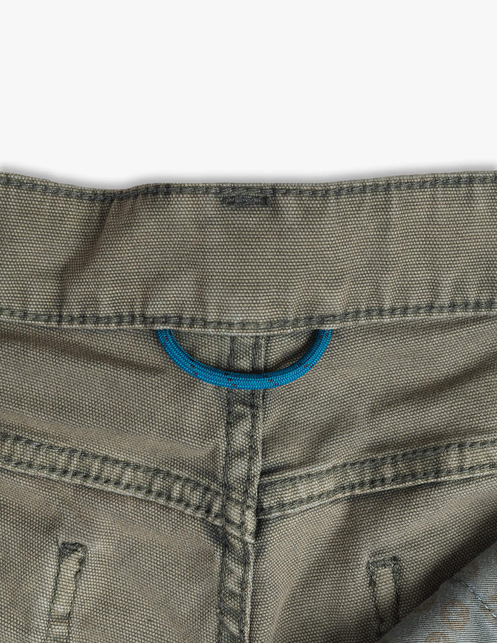 Back waistband of khaki pants showing a centered blue fabric D-ring loop above the rear seam.