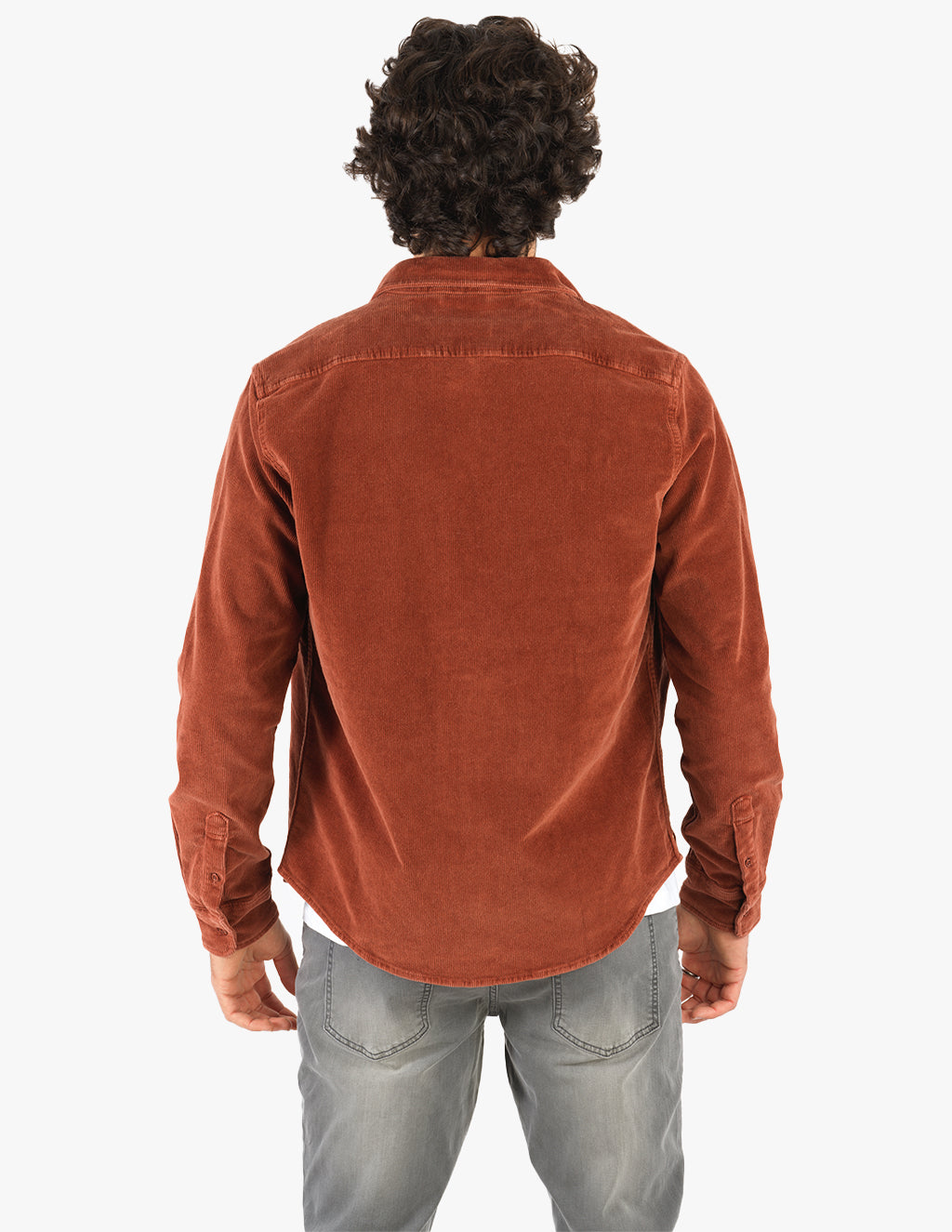 Rear view of person wearing rust corduroy button-up shirt and faded gray jeans
