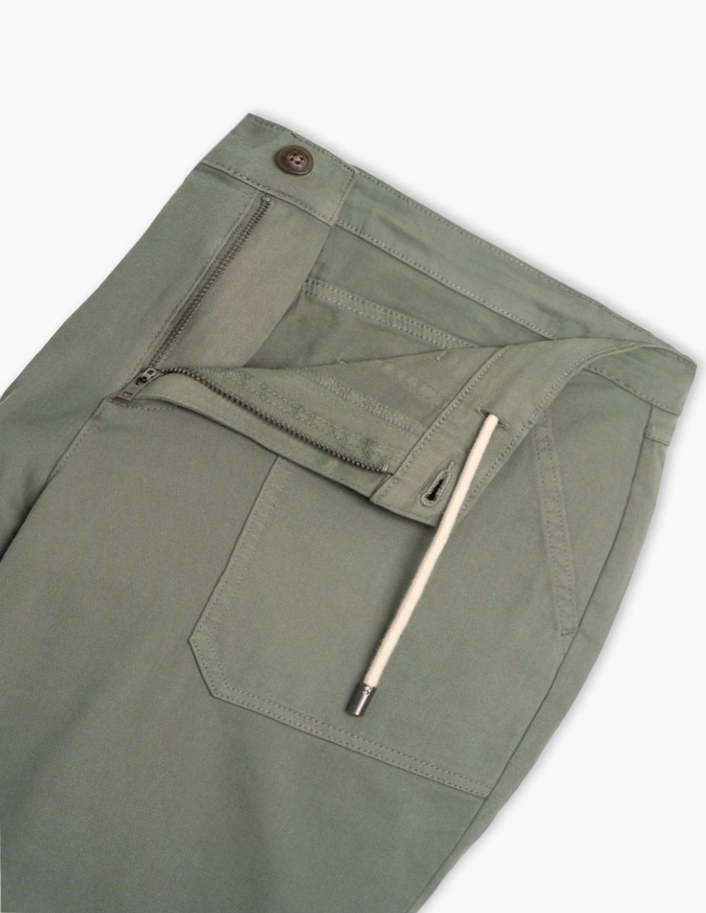 Close-up waist view of Seagrass drawstring pants showing open zipper, button, front patch pocket and white drawstring