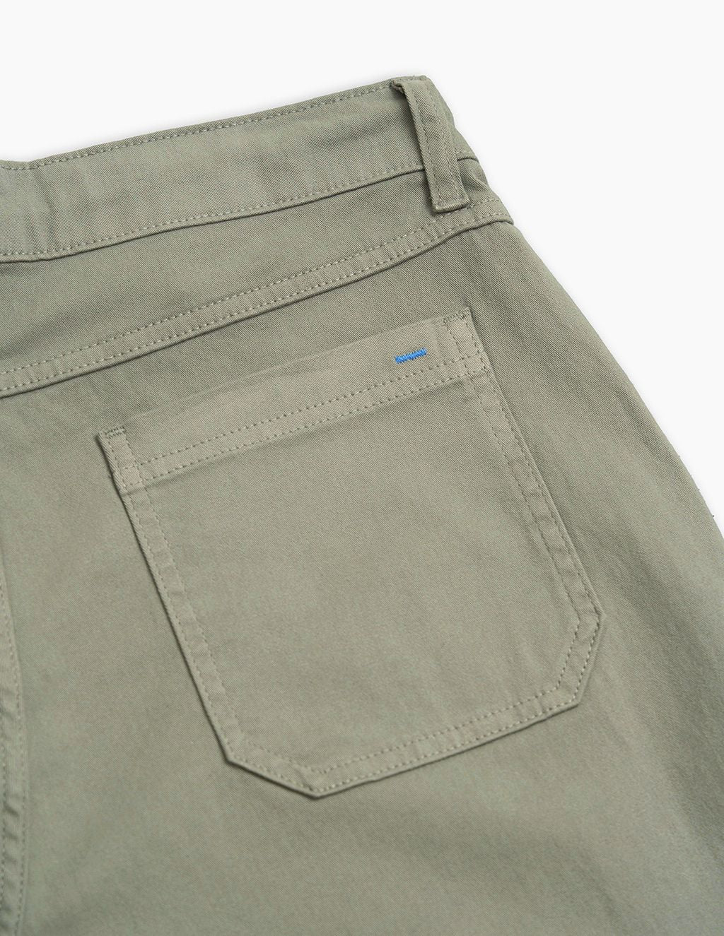 Olive-green pants back pocket with topstitching and small blue embroidered tab