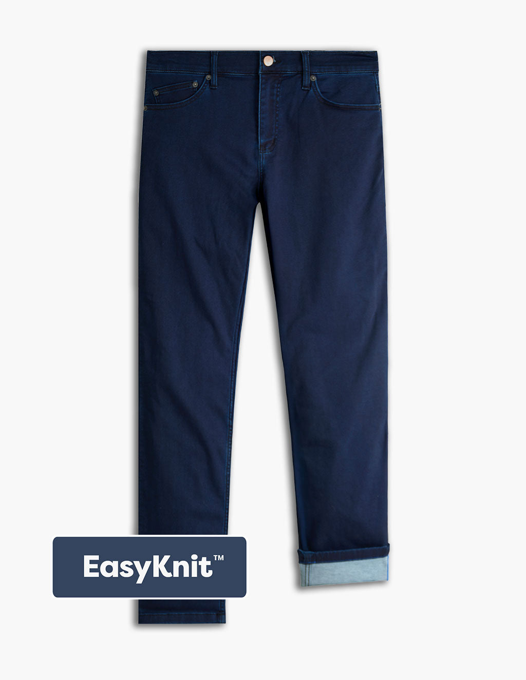 Flat lay of Studio Blues EasyKnit jeans showing dark blue knit denim with rolled cuff and EasyKnit badge on white background